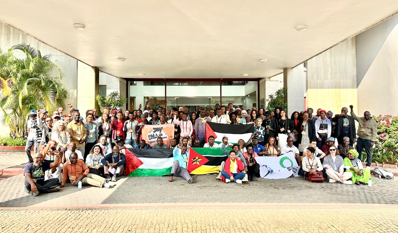 Participants at the 10th Maputo Workshop on Corporate Impunity gathered outside the venue with flags and banners.