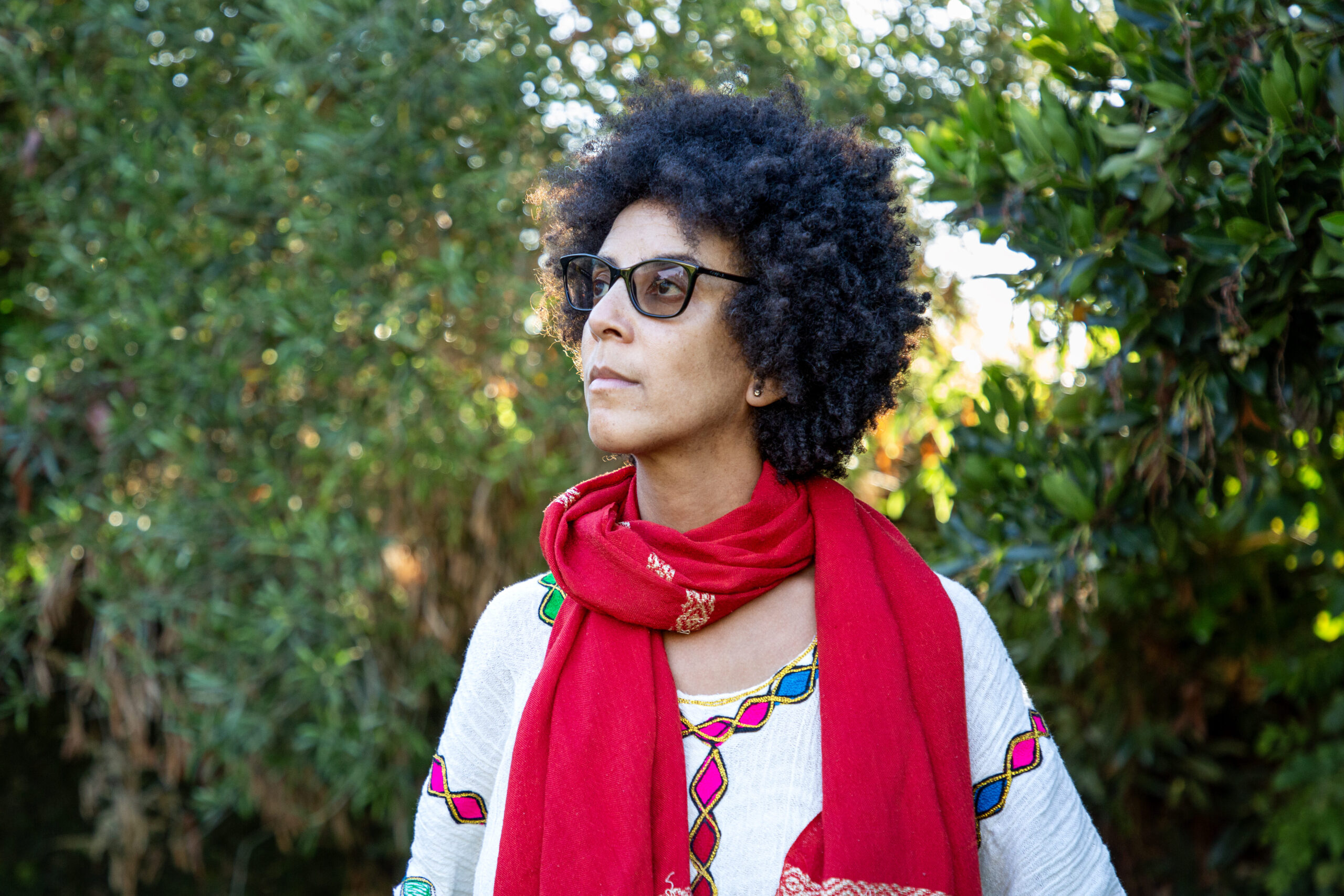 2026 Right Livelihood Laureate Timnit Gebru in garden, looking off to the side.