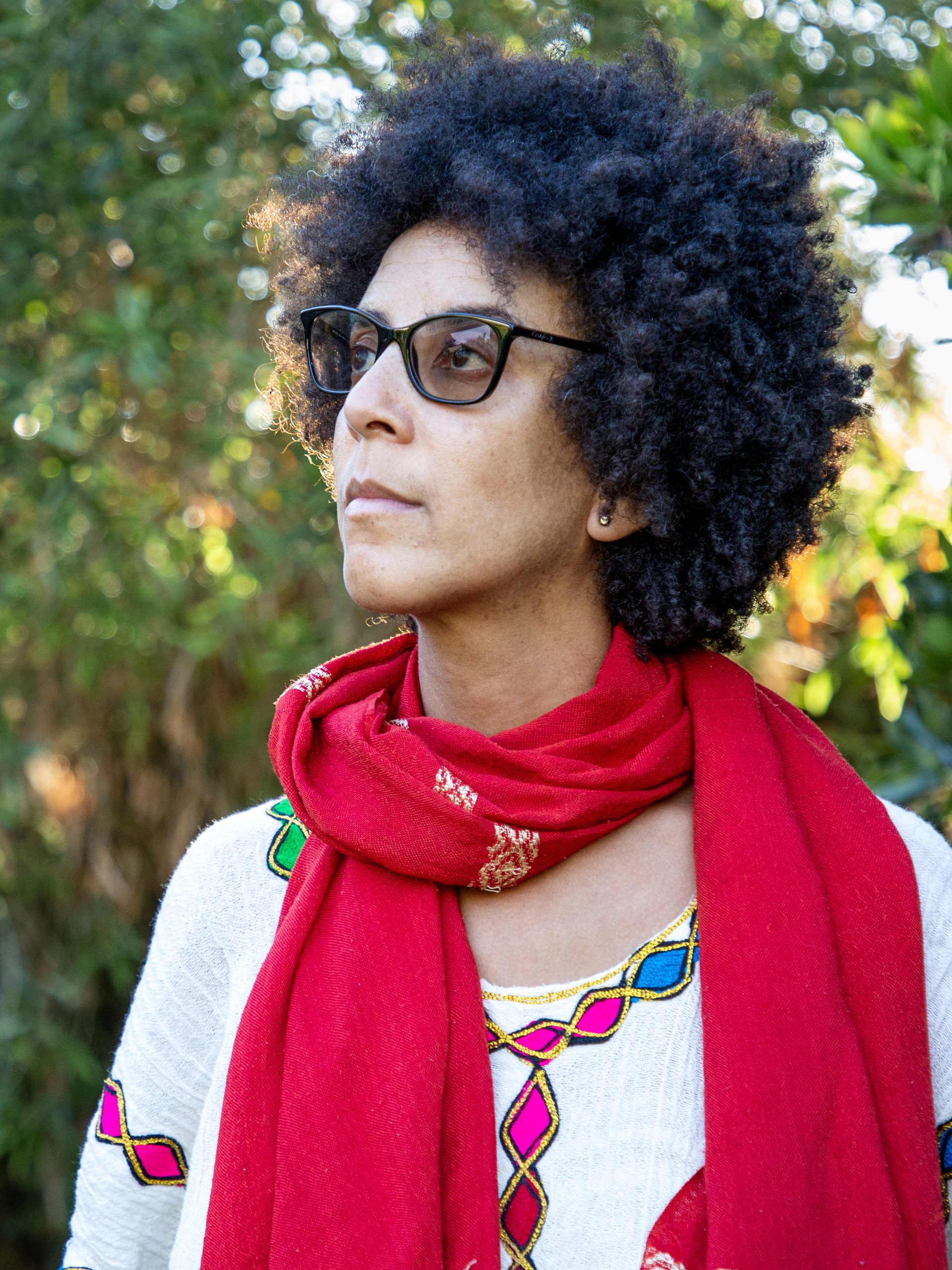 2026 Right Livelihood Laureate Timnit Gebru in garden, looking off to the side.